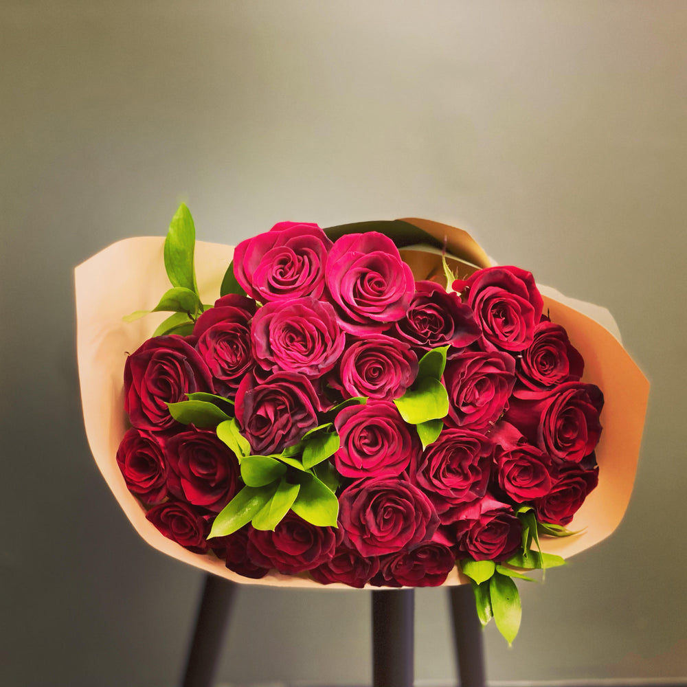 Luxurious bouquet of long stem red roses, showcasing deep red blooms and fresh greenery