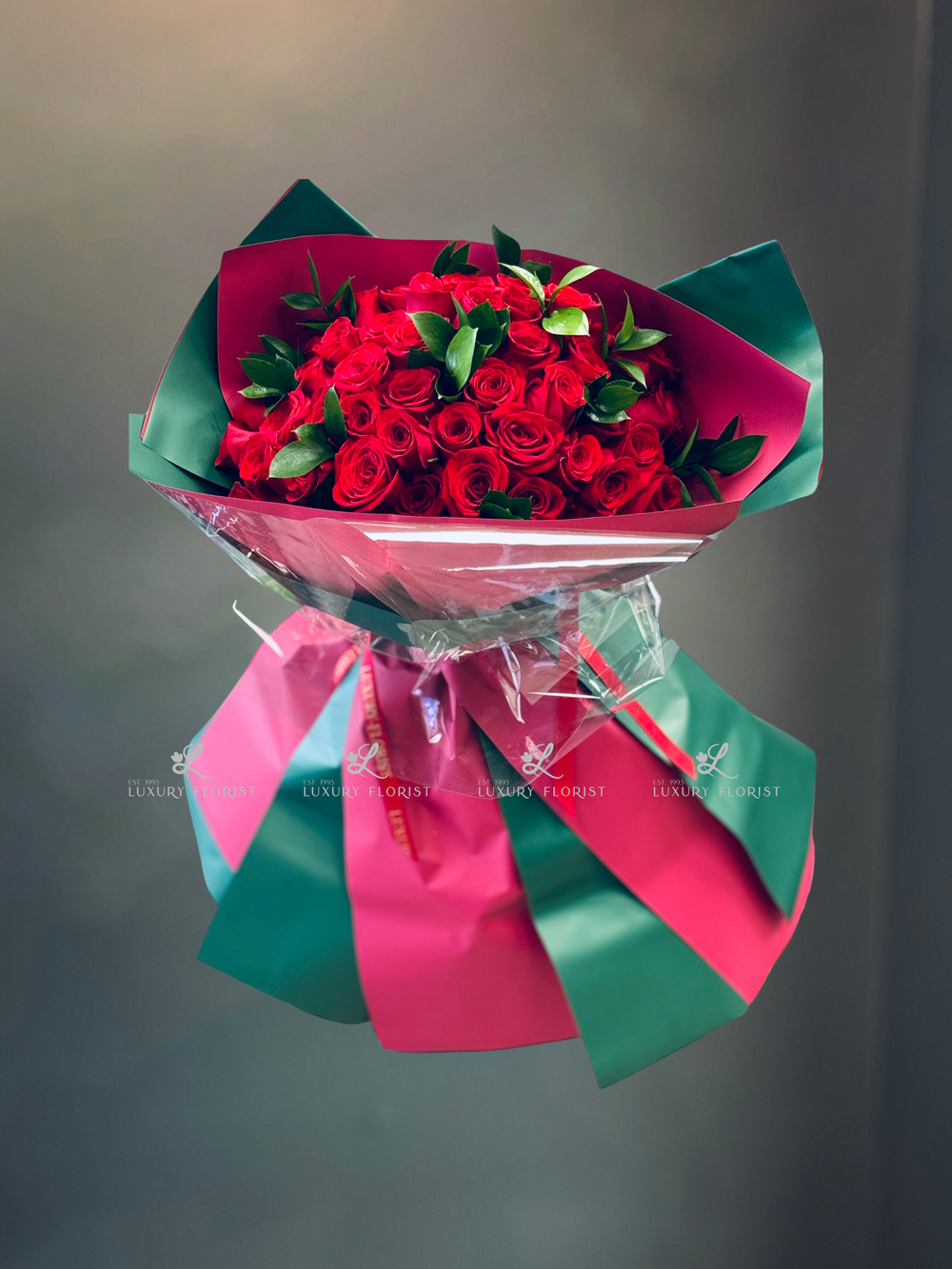 Elegant long stem red roses with lush green leaves, perfect for romantic gifts