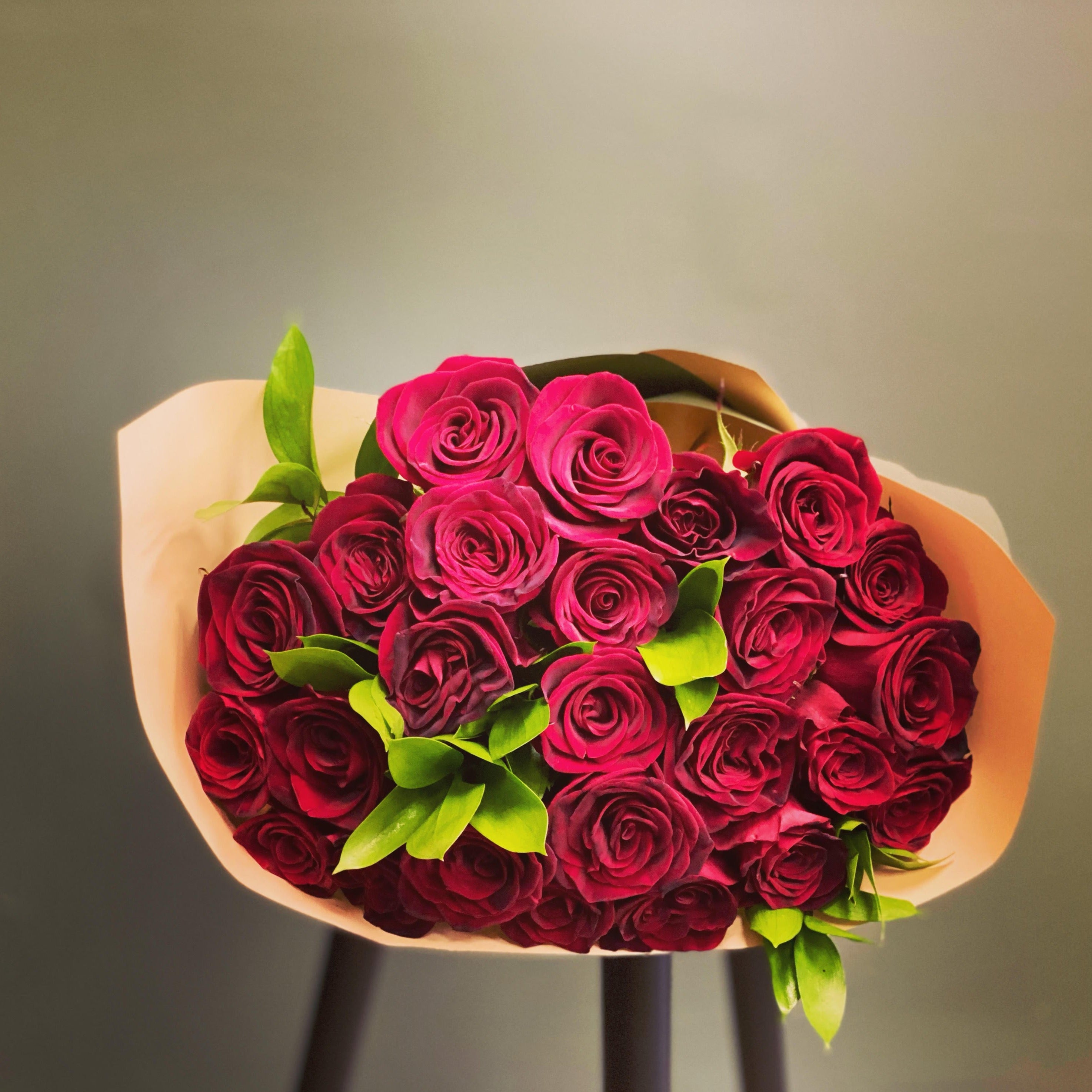 Elegant long stem red roses with lush green leaves, perfect for romantic gifts