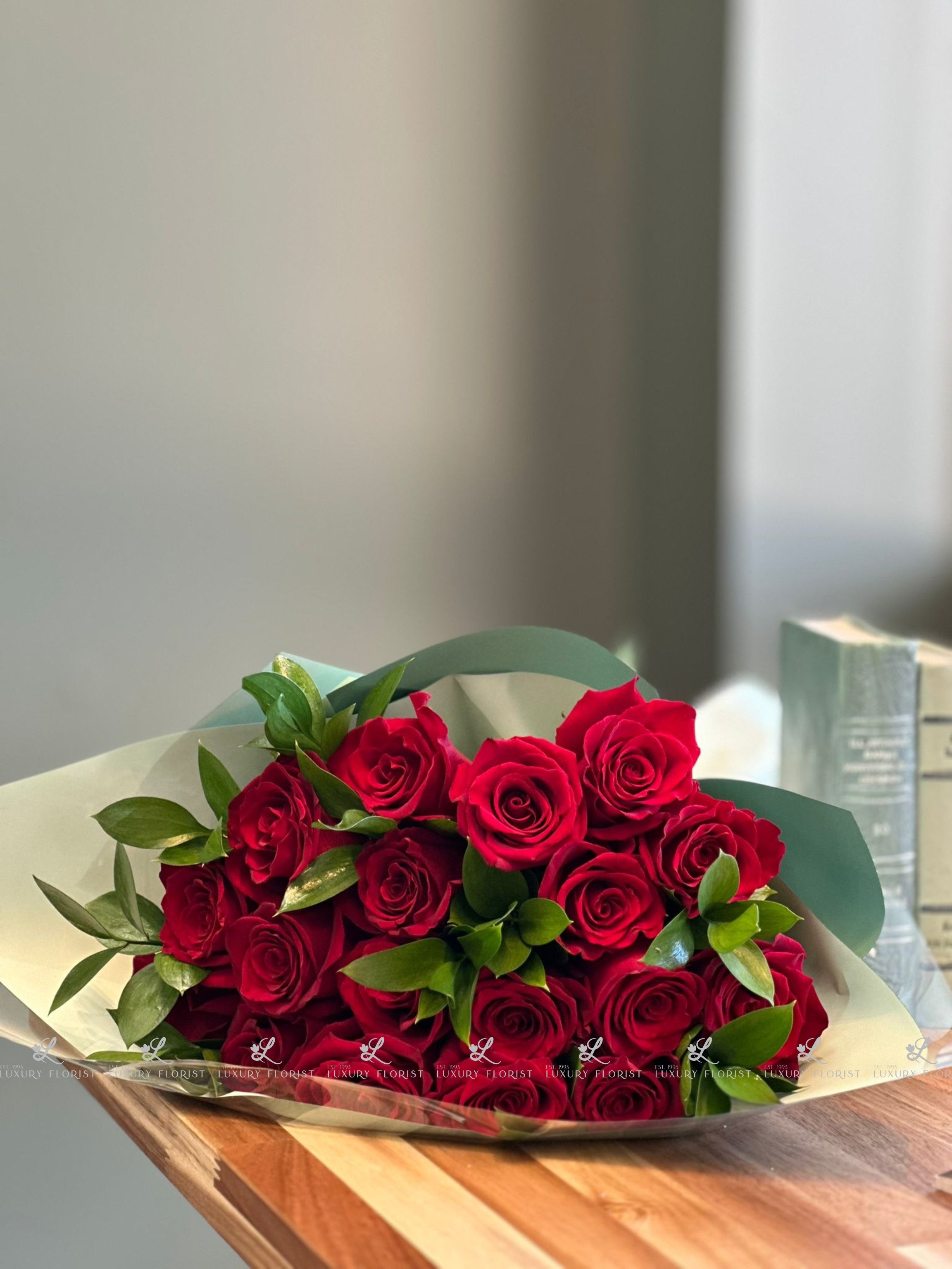 Elegant long stem red roses with lush green leaves, perfect for romantic gifts